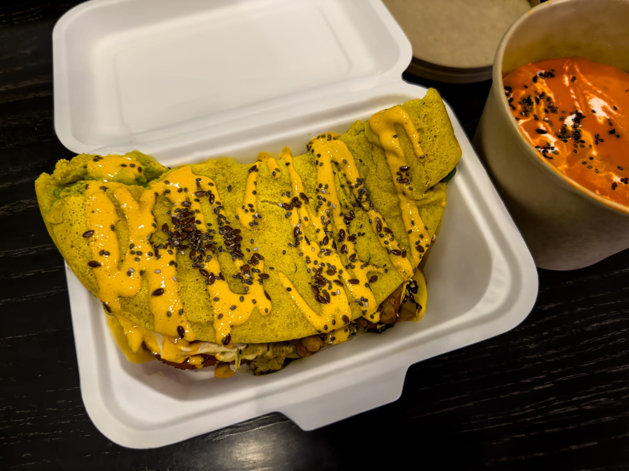 Vegan chickpea omelette at Kurumi in Hội An topped with creamy sauce and seeds, served alongside a bowl of coconut cream tomato soup