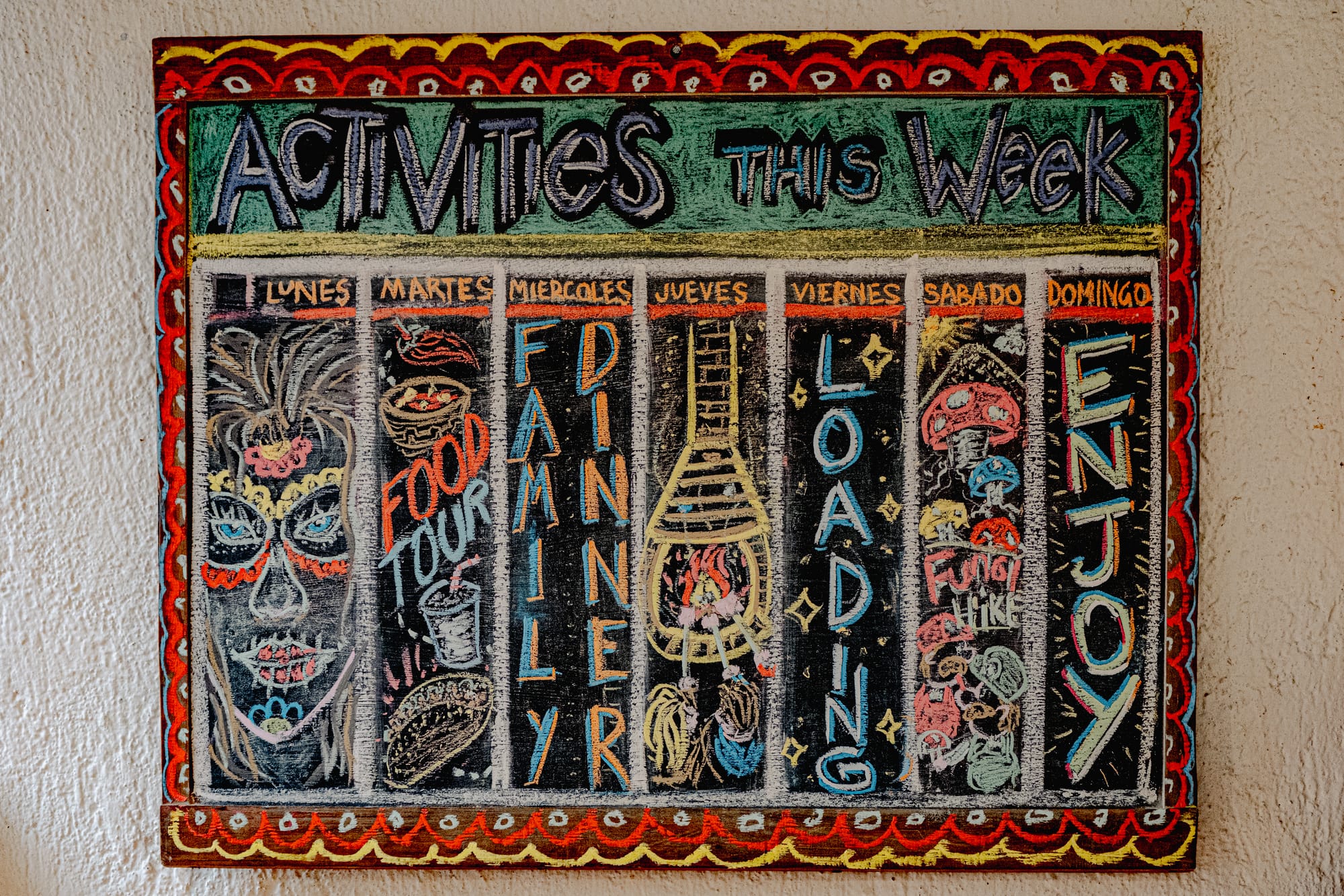 Hand-drawn weekly activities board at Co404 coliving in San Cristóbal de las Casas, listing events like food tours, family dinner, and hikes