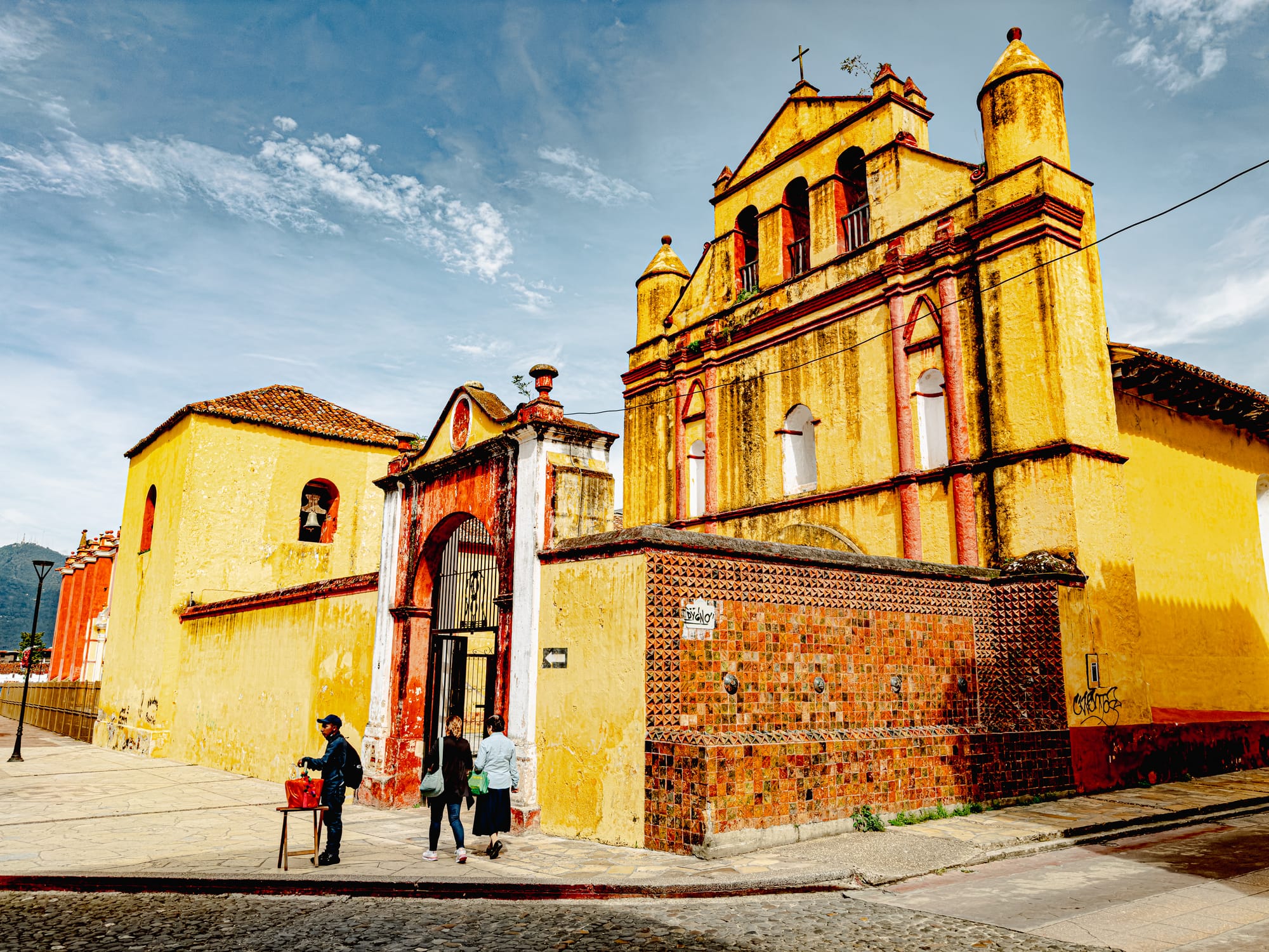 Digital nomad life in San Cristóbal de las Casas Mexico, yellow colonial church in the historic center, traditional church architecture in the Chiapas Highlands, walkable neighborhood with everyday life, cultural and religious landmark for digital nomads and remote workers, historic streets of San Cristóbal in southern Mexico