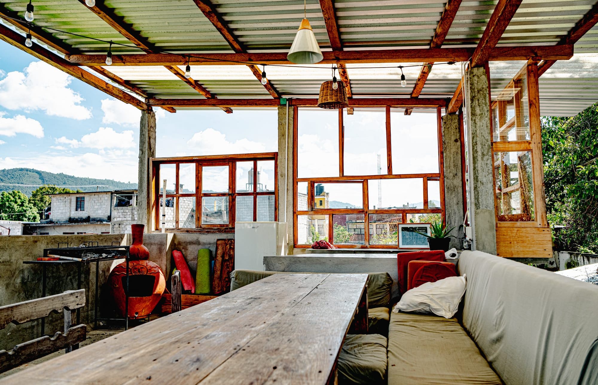 Digital nomad life in San Cristóbal de las Casas Mexico, Co404 coworking and coliving space in the Chiapas Highlands, open air communal workspace with wooden tables and mountain views, remote work environment for digital nomads, creative slow living atmosphere, digital nomad and remote worker base in southern Mexico