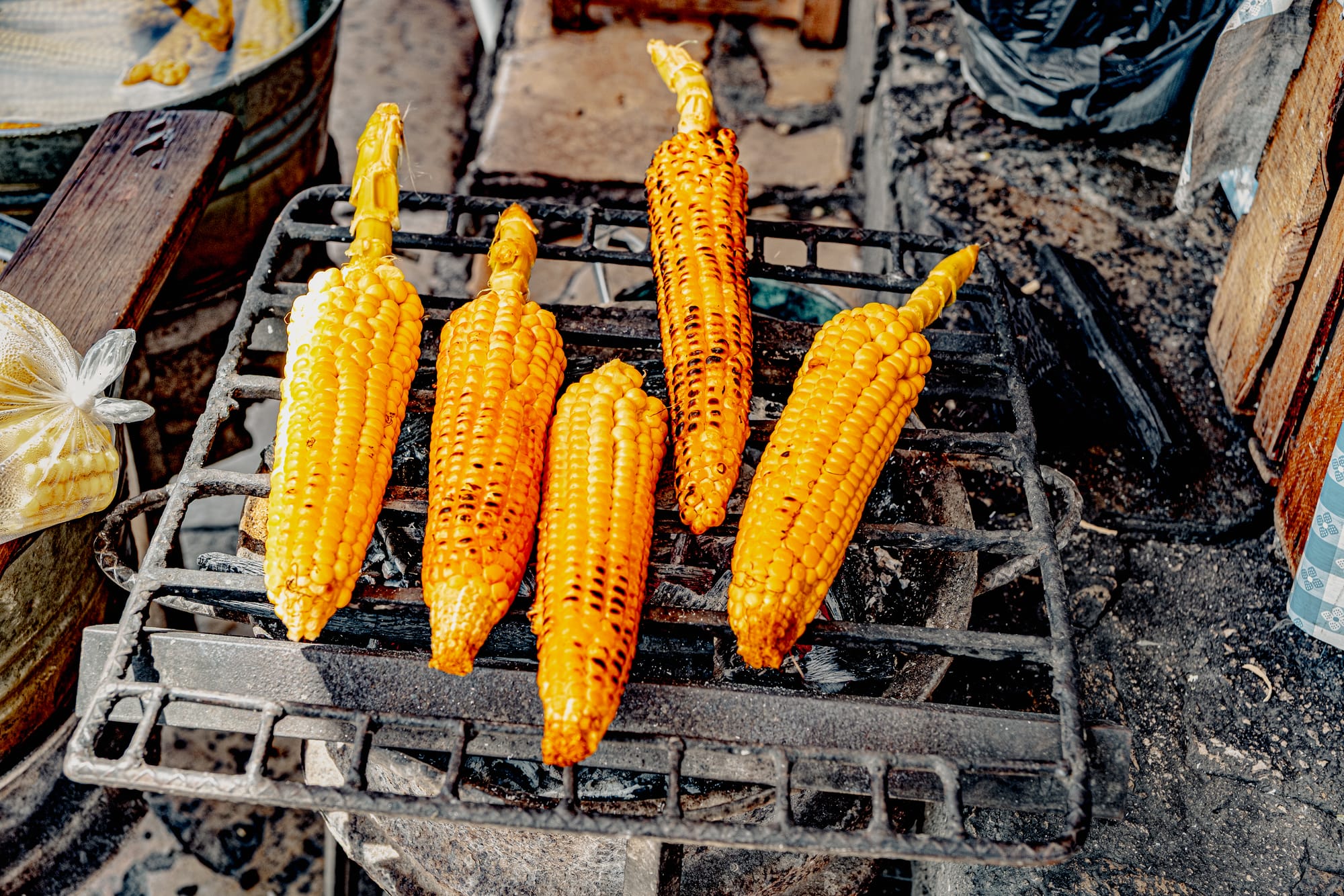 Digital nomad life in San Cristóbal de las Casas Mexico, street food corn grilling over charcoal in the Chiapas Highlands, traditional elote prepared by local vendor, everyday food culture in San Cristóbal, affordable local food for digital nomads and remote workers, daily life in southern Mexico