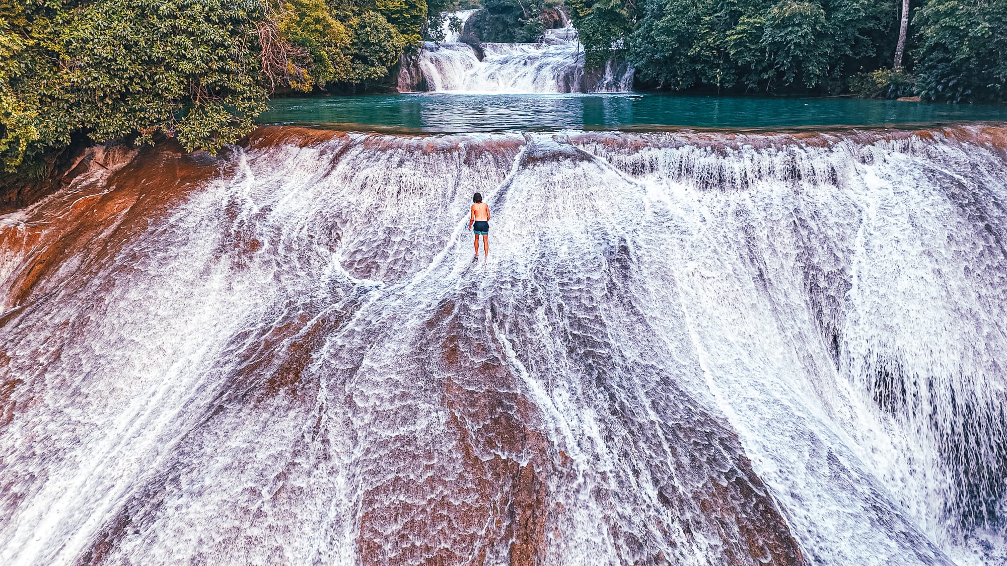 Cascadas Roberto Barrios waterfalls near Palenque, Chiapas, Mexico, person standing on wide sloping limestone waterfall, walkable cascades and flowing water, jungle waterfalls with turquoise pools, Roberto Barrios natural swimming area day trip from Palenque