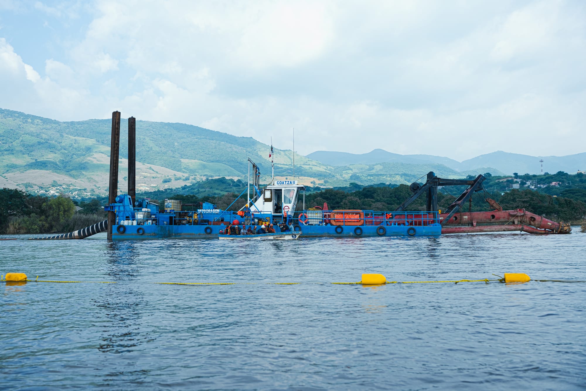 Dredging barge and equipment on the Grijalva River near Chiapa de Corzo, seen during the Sumidero Canyon boat tour with the green hills of Chiapas in the background