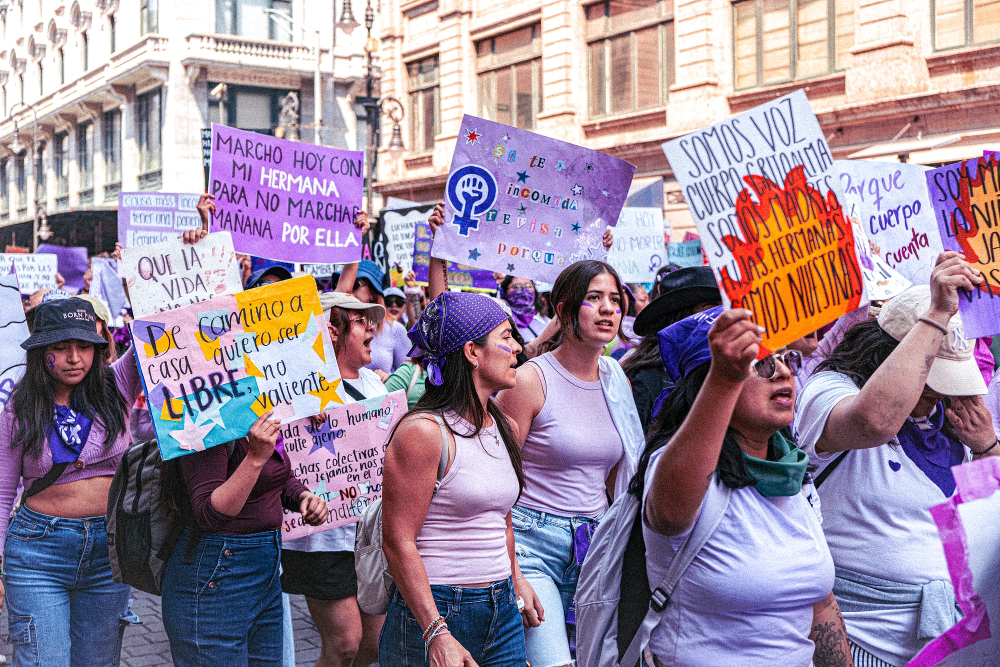 Feminist protesters holding colorful signs during the 8M march in Mexico City on International Women’s Day