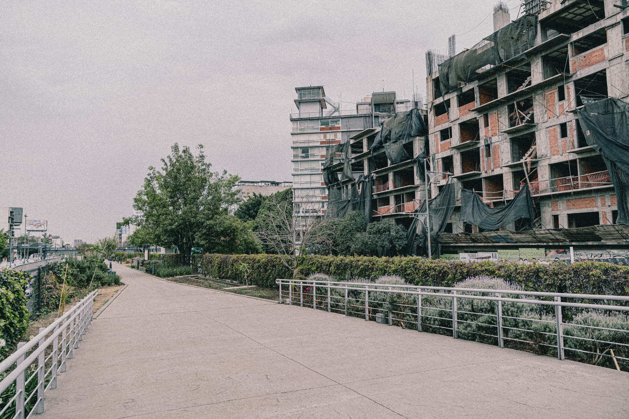 Parque Lineal Viaducto path with dilapidated building in the background