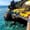 Swimmer floating in turquoise water below yellow umbrellas and cliffside sun decks at İnciraltı Beach in Antalya, Turkey