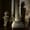 A dimly lit sculpture of a figure with serpentine hair sits beside a column inside the Basilica Cistern, casting a haunting shadow on the brick wall behind it