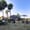 People relaxing on mats and benches in a grassy open yard at Cocoon in Chiang Mai
