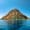 Suluada: a rocky island rising from vivid turquoise waters on a clear, sunny day