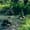 Stacked stone cairns in the middle of a flowing river surrounded by lush green vegetation in Ihlara Valley