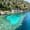 Submerged stone structures of Kekova’s ancient port visible beneath clear turquoise water, with kayakers paddling nearby along the rocky shoreline