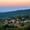 View of Mae Rim’s rolling hills at sunset, with forested slopes, scattered farms, and soft pastel colors in the sky