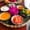 Colorful tray of Vietnamese cooking ingredients with chili, garlic, lime, turmeric, shallots, passionfruit juice, and flower decoration