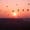 Hot air balloons rising over Cappadocia at sunrise viewed from behind Uçhisar Castle ridges